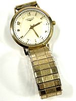 Close-up of the front face showing the dial, Longines brand name, and gold tone hour, minute, and second hands. The watch is set to approximately 2:13.