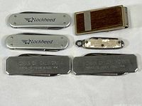 Top down view showing all five pocket tools and the wood inlaid money clip arranged on flat white surface.