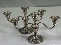 Pair of weighted sterling silver candelabras with three curved arms each, floral base detail