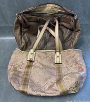 Overview photo of the two designer bags placed together, showing the Gucci tote on front and the brown leather J.Crew bag behind it.