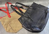 Both handbags arranged together showing the beige monogram Lauren RL bag with red leather handles and the black leather Cole Haan bag