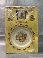 Front view of one dinnerware package with a plate and a mug, featuring Bunnykins imagery and packaging marked Bunnykins with bunny border illustrations.