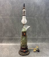 Full unlit view of carved quartz lamp with metal base