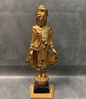 Front view of full standing Buddha statue on pedestal