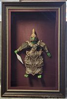 Full view of the framed Thai Rama Khon Lakhon folk art figure showing the entire figure inside the shadow box frame against a dark background.