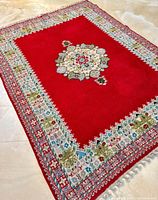 Full view of rectangular rug laid on floor showing central medallion and patterned border