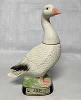 Front view of vintage Jim Beam goose whisky decanter showing detailed painted ceramic goose, label on base and stopper neck form.
