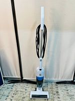 Full front view of the BISSELL 3-in-1 Turbo Lightweight Stick Vacuum upright with power cord wrapped around handle.
