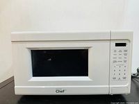 Front view of the white Master Chef microwave oven showing the window, controls, and logo.