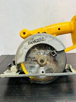 Close-up photo showing the DeWalt circular saw blade with markings for paneling and vinyl siding cuts.