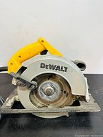 Close-up side view of DeWalt corded circular saw highlighting blade guard and yellow handle.