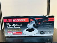 Front box image showing Drill Master logo, 7" variable speed polisher/sander description, item number 92623, and key features