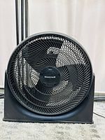 Front view of a black Honeywell 18-inch TurboForce floor fan, showing three blades behind protective grill.