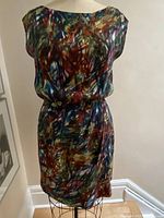 Full view of dress on mannequin showing abstract print in muted colors and gathered waist