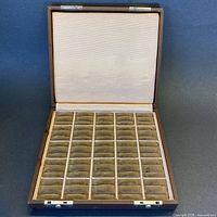 Open vintage brown leatherette ring storage box showing taupe velvet interior with 50 cushioned ring slots.