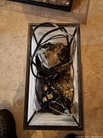 Top view inside the aquarium showing electrical cords, pumps, and decorative rocks inside the tank.