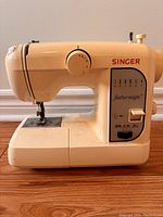 Side profile view of the Singer Featherweight sewing machine showing controls and branding