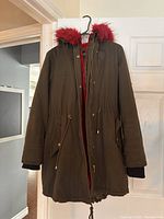Front view of the dark fall coat with visible hood and zipper front, showing overall condition and design.