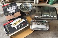 Electric stainless steel buffet server with three covered warming compartments, box and two Gourmet Buffet chafing dishes with lids.