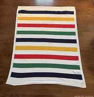 Full view of small Hudson’s Bay throw blanket with multicolor stripes.