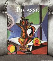 Front cover of the hardcover art book showing colorful cubist still life painting with abstract jug and fruit.