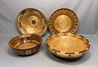 Four hand-turned wooden bowls showing varied wooden segment patterns and sizes.