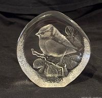 Front view showing detailed bird design and signature on glass base