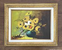 Full view of framed still life oil painting showing yellow flowers in green vase against a muted background.