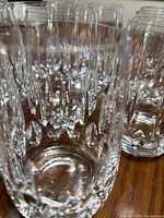 Close-up of clear crystal whiskey glasses with cut pattern on wooden surface.