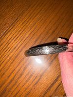 Close-up of silver bangle showing engraved decorative patterns