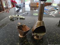 Two handcrafted copper items on dark surface: coal bucket and stove pipe ashtray.