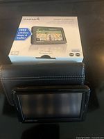 Photo of Garmin nüvi 1490LMT GPS navigation device with original retail box, showing front packaging and device screen.