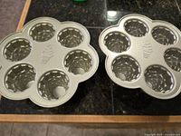 Two Nordic Ware cupcake pans made from heavy aluminum, each with six ice cream cone shaped molds and detailed texture on molds.