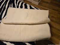 Folded blanket showing backing fabric and wool pile edge