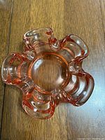 Top view highlighting the clear pink glass, wavy edges, and central bowl.