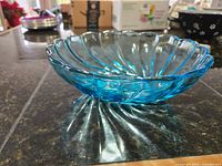 Side view of the blue glass swirl bowl showing its scalloped edges and thickness
