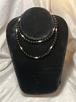 Front view of necklace on black velvet display showing bead details and arrangement.