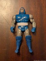 Front view of the Darkseid 5.5 inch action figure showing blue helmet, blue gloves, boots, and gray muscular arms and torso with white belt.