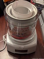 Cuisinart ice cream maker showing the top and the clear mixing bowl with text and paddle inside.