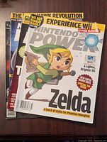 Front covers of four Nintendo Power magazines stacked, featuring Zelda Phantom Hourglass artwork and gaming content.