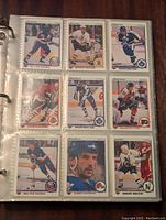 Photo of three binder pages showing 1990-91 Upper Deck NHL hockey cards featuring various players.