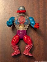 Front view of the He Man Roboto action figure showing the transparent chest with visible gears, blue arms, red legs, purple waist, and robot head.