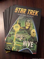 Six hardcover Star Trek comic books stacked, showing cover titled 'Hive' with character and starship imagery.