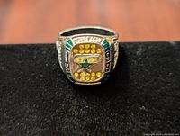 Front view photo of the 1999 Dallas Stars Stanley Cup championship ring showing team logo, yellow stones, and green side accents.