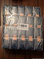Pack of 20 unopened pocket tissue packages wrapped in plastic with dark blue packaging and light edges.