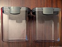 Two large transparent plastic Starfrit Prokeeper containers with gray locking lids, viewed from the front and top angles to show condition and features.