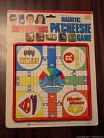 Front view of the SuperFriends Magnetic Parcheesi Game showing Batman, Superman, Wonder Woman, and Robin playing spots and magnetic pieces.