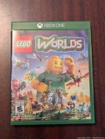 Front cover of Xbox One Lego Worlds game case showing colorful LEGO character and game title