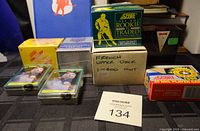 Photo showing 8 card sets and singles from 1990s including Score hockey cards, Upper Deck French set 1-400 cards, Black Box set missing hologram, loose cards in plastic cases, and unopened boxes