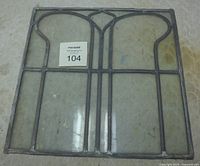 Full view of antique leaded glass window panel showing overall design and size with auction label visible